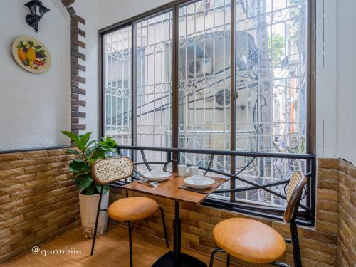 a balcony with a table and chairs and a window at Kansas Hotel & Apartment - Notre Dame in Ho Chi Minh City