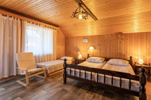a bedroom with two beds and a chair at Apartment and room Mateja Kovačič in Bohinj