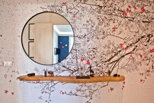 a mirror on a wall with red flowers at JOIVY Luxury 3 bed, 3 bath flat with terrace, near Estrela Garden in Lisbon