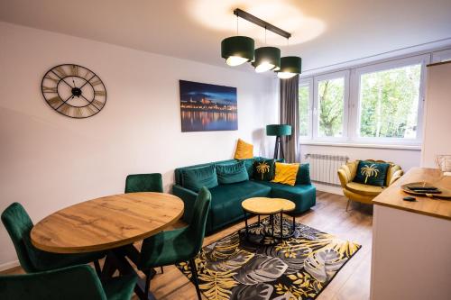uma sala de estar com um sofá verde e uma mesa em Apartament Verde em Toruń