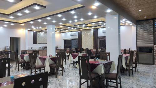 a restaurant with tables and chairs in a room at Petra Guests Hotel in Wadi Musa