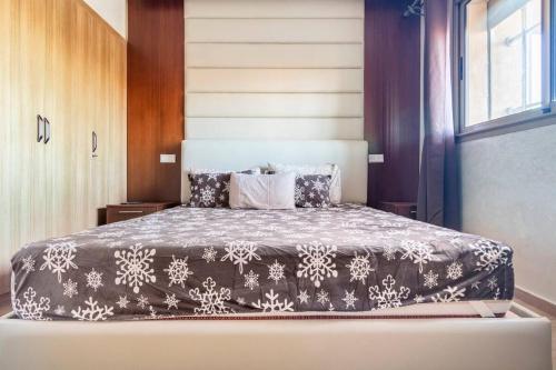 1 dormitorio con 1 cama con manta blanca y negra en New luxury apartment in Marrakech, en Marrakech