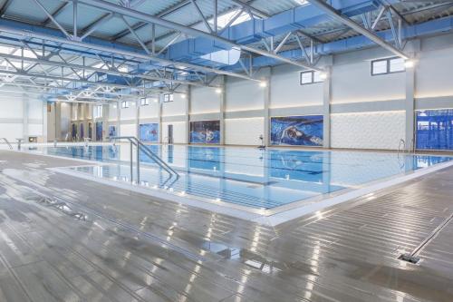 une piscine vide avec un sol en difficulté et des plafonds bleus dans l'établissement Lux Apartman Sunce, à Jagodina