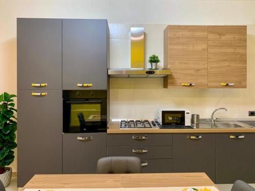 a kitchen with a sink and a stove top oven at Griseo - Sicily Holiday House in Misterbianco
