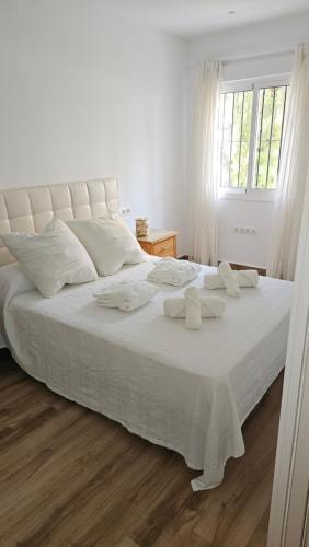 a white bed with white sheets and pillows on it at stylish apartment Marbella old town in Marbella