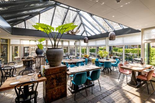 a restaurant with tables and chairs and a large glass ceiling at Broeck Oudewater in Oudewater