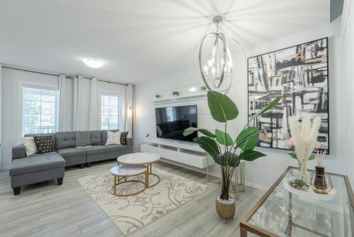 a living room with a couch and a tv at 3bedroom Stylish Getaway by the Park with 2-Car Garage in Calgary