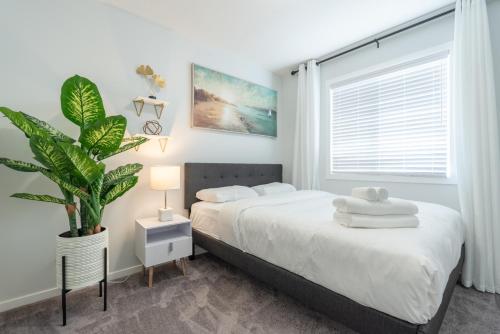 a bedroom with a bed and a potted plant at 3bedroom Stylish Getaway by the Park with 2-Car Garage in Calgary