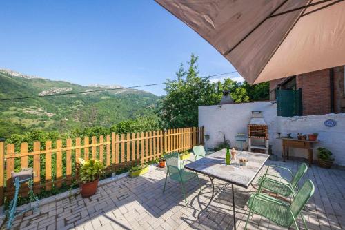 a patio with a table and chairs and a fence at Carbayu Senda del Oso in Proaza