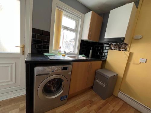 a kitchen with a washing machine and a sink at Newcastle, Powburn, fully equipped kitchen 4 bedrooms, 3 king & 2 single beds in Newcastle upon Tyne
