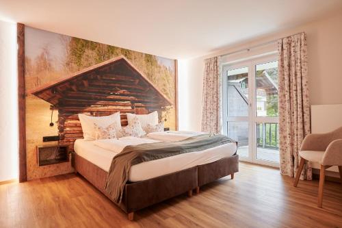 a bedroom with a large bed and a large window at Oberstdorfer Ferienwelt in Oberstdorf