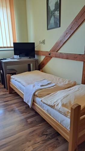 a bedroom with two beds and a desk with a laptop at Penzion Bruder in Mojmírovce