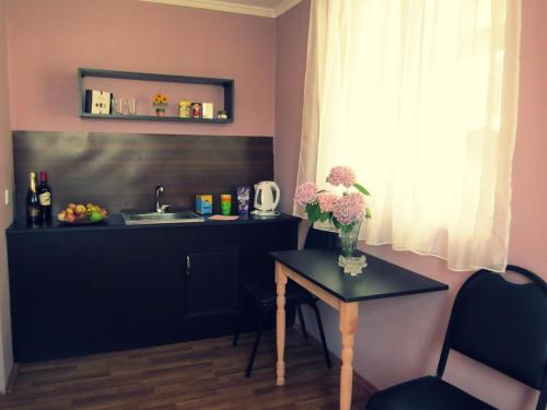 a small table with a vase of flowers and a sink at The Kiwi House in Lagodekhi