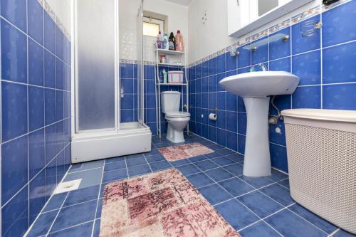 a blue tiled bathroom with a sink and a toilet at Refreshing Villa near Milas-Bodrum Airport in Gulluk