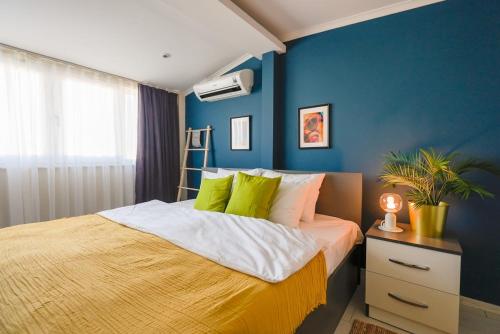 um quarto com paredes azuis e uma cama com almofadas verdes em Stylish Flat Near Hadrians Gate em Antalya
