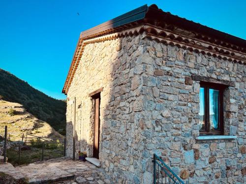 a stone building with two windows on the side of it at Laura Guest House Sasso di Castalda in Sasso di Castalda