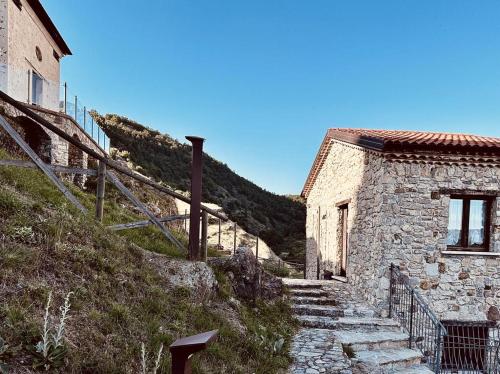 - un bâtiment en pierre avec des escaliers menant à une colline dans l'établissement Laura Guest House Sasso di Castalda, à Sasso di Castalda