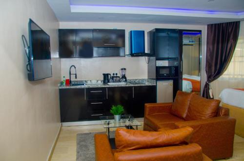 NO 95 SUITES VI في لاغوس: غرفة معيشة مع أريكة ومطبخ