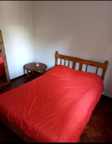1 dormitorio con cama roja y mesa en Habitación en Plena Ciudad de Mendoza en Mendoza