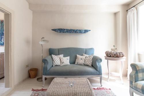 ein blaues Sofa im Wohnzimmer mit einem Tisch in der Unterkunft Das Fachwerkhäuschen am Kornmarkt - herzlich & charmant in Quedlinburg