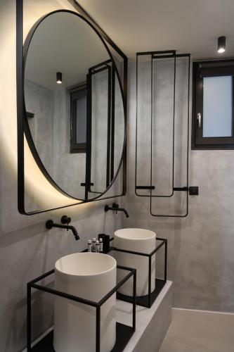 a bathroom with two sinks and a large mirror at Apikia Santorini in Pirgos
