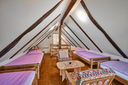 a attic room with beds and a table and chairs at Kuća za odmor s bazenom TeriHy in Klake