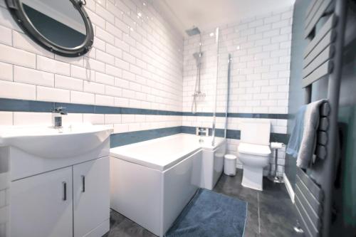 een badkamer met een wastafel, een bad en een toilet bij Horizon in Hastings