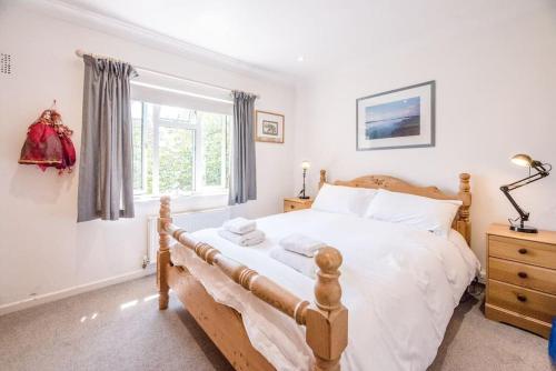 um quarto com uma cama de madeira e uma janela em Number 27, Alderton em Woodbridge