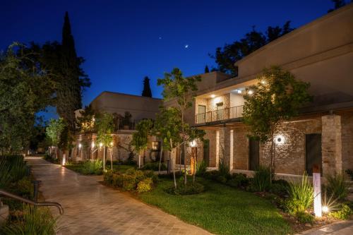 a house with lights on the side of it at night at Ayala by Isrotel Collection in Ayelet HaShahar