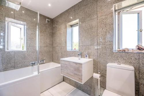 ein Badezimmer mit einer Badewanne, einem WC und einem Waschbecken in der Unterkunft Number 27, Alderton in Woodbridge
