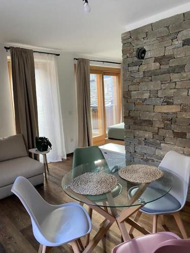 a living room with a glass table and chairs at ChaletMagnan in Lanzada
