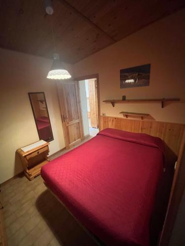 a bedroom with a large red bed in a room at Il Covo House in Roccaraso