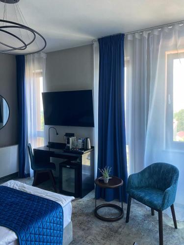 a bedroom with a bed and a desk and a chair at Hotel Sanova in Jarosław
