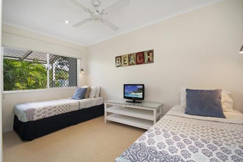 a bedroom with two beds and a television in it at 44 Cooran Court in Noosa Heads