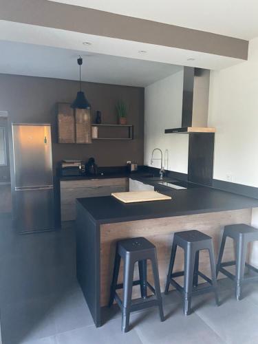 une cuisine avec trois tabourets de bar et un îlot de cuisine dans l'établissement Casa di Laura, à Cervione