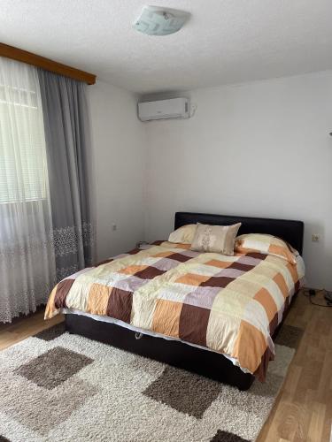 a bedroom with a bed and a window at Muzur Apartment in Sarajevo