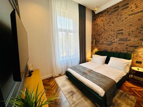 1 dormitorio con cama y pared de ladrillo en Olimpia Residence Palace Oradea, en Oradea