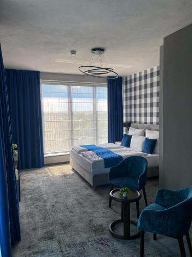 a bedroom with a bed and blue curtains at Hotel Sanova in Jarosław