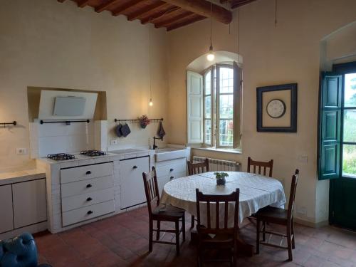 eine Küche mit einem Tisch und Stühlen sowie eine Küche mit einem Herd in der Unterkunft Casa Garibaldi in Lucca