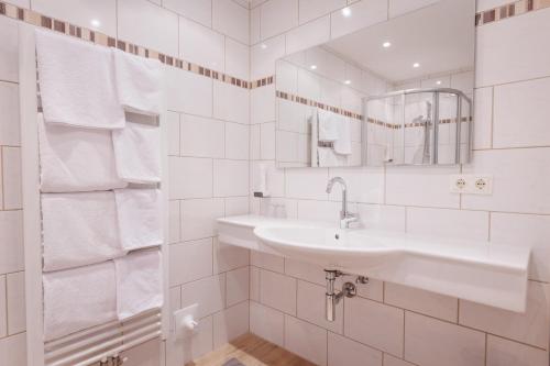 Baño blanco con lavabo y espejo en hin&weg das Aparthotel, en Ried im Zillertal
