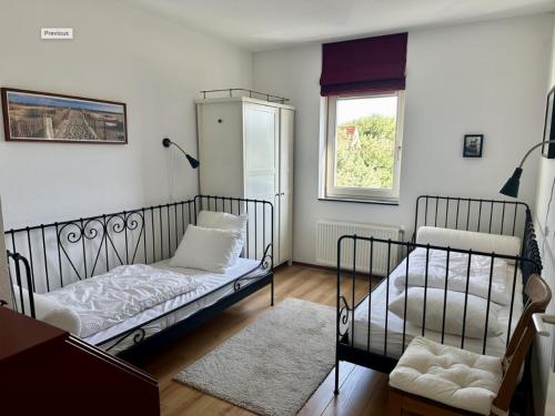 ein Wohnzimmer mit 2 Betten und einem Fenster in der Unterkunft Duinerei appartement A101 in Groote Keeten