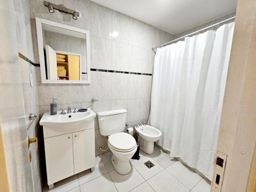 Baño blanco con aseo y lavamanos en Casa en Salta en Salta
