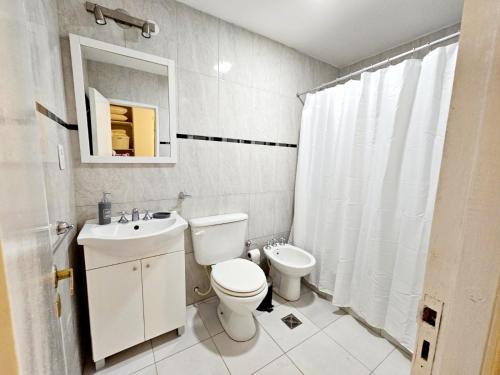 a white bathroom with a toilet and a sink at Casa en Salta in Salta