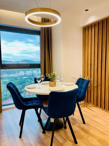 uma sala de jantar com mesa e cadeiras e uma grande janela em 19th floor Apartment em Cluj-Napoca