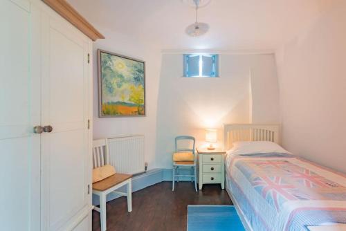 a bedroom with a bed and a desk and a chair at The Secret Garden in Kingsdown