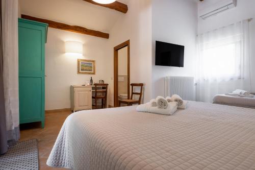 a bedroom with a white bed with towels on it at Cerchio Verde in Pitigliano
