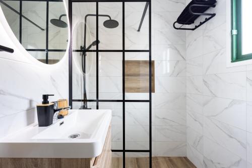 ein Badezimmer mit einem weißen Waschbecken und einem Spiegel in der Unterkunft Acogedor Apartamento con vistas al mar en Costa Adeje in Adeje