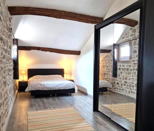 Schlafzimmer mit einem Bett und einem Spiegel in der Unterkunft Les Hauts de CLuny in Cluny