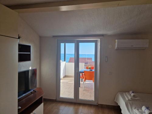 a room with a door leading to a patio with a table at Villa Gaj in Novalja
