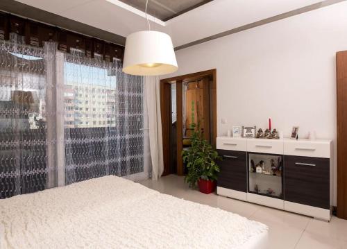 a bedroom with a white bed and a large window at OrangeHomes One bedroom apartment with fireplace in Budapest